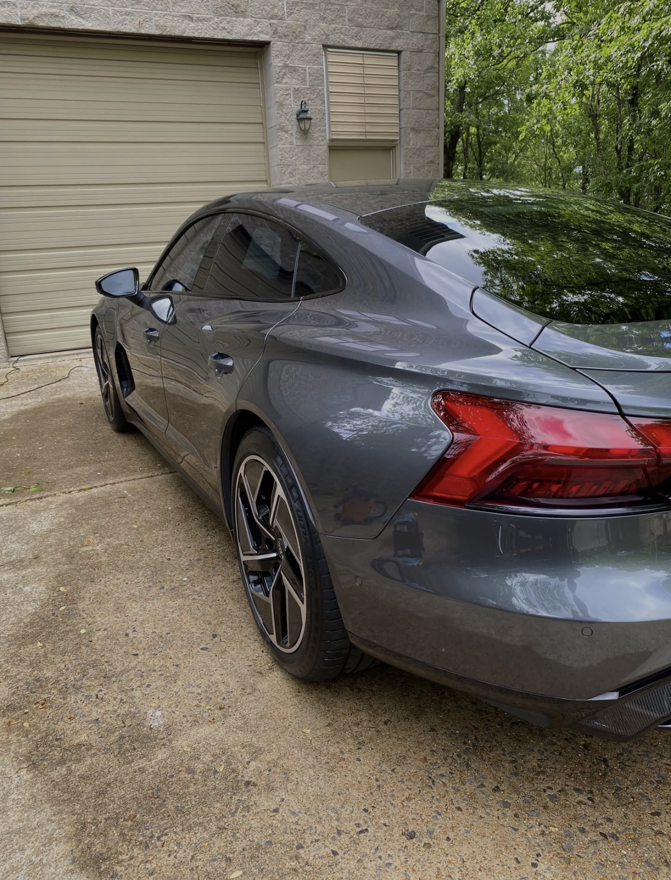 Audi e-tron GT rear three-quarter after detail — deep gloss and clean wheels