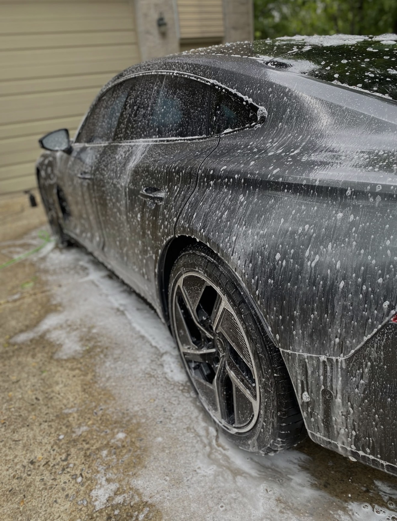 Audi e-tron GT rear quarter draped in snow foam during exterior wash