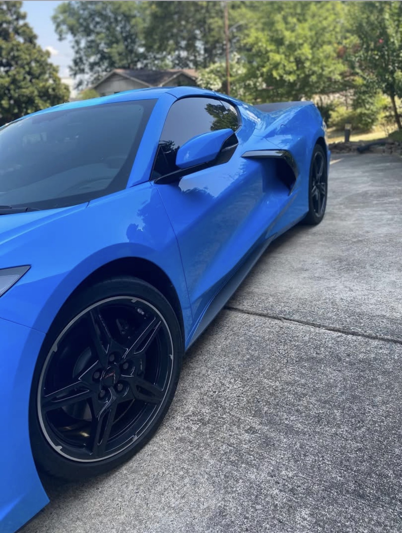 Freshly detailed blue C8 Corvette side profile with mirror-finish paint